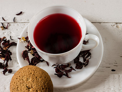一杯卡卡德红茶，木桌上有干花和饼干