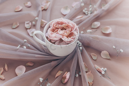 大气背景婚礼摄影照片_大气浪漫的构图，杯子里有薄纱和粉红玫瑰。