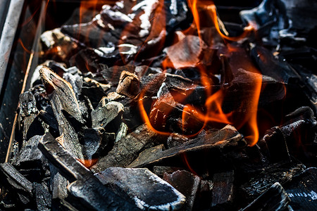 烧烤炉坑，带有红色火焰、热木炭煤球和余烬的发光和燃烧的热明火