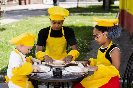 跨国儿童公司穿着黄色制服为面包店做饭。
