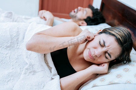 妻子因丈夫熟睡时打鼾而痛苦。