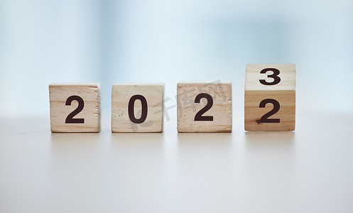 日历、2023 年倒计时和灰色工作室背景中空桌子上的木块，以实现目标或解决方案。