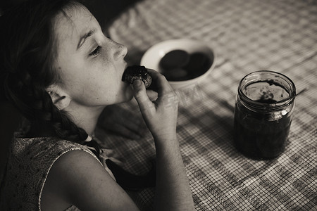 可爱有趣的幼儿女孩早餐吃甜面包。