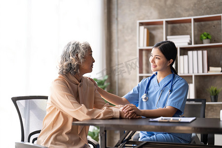 年轻的亚洲女性或护士护理手放在老祖母的肩膀上，为老年妇女或老年人提供同情心，帮助护理心理健康疾病救济概念手扣鼓励