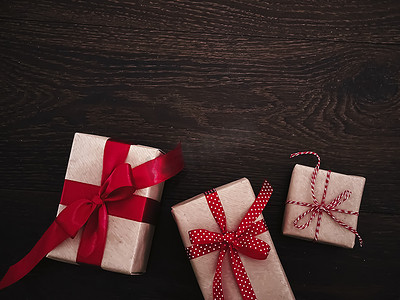 圣诞礼物和传统节日礼物，木质背景的经典圣诞礼盒，用红丝带工艺纸包裹的礼物，复古乡村风格的季节性节日