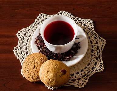 一杯卡卡德红茶，木桌上有干花和饼干