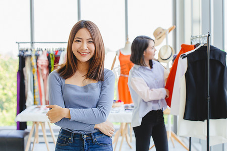 肖像年轻的亚洲中小企业企业主开心地微笑着她的新服装店盛大开业日促销和客户服务。