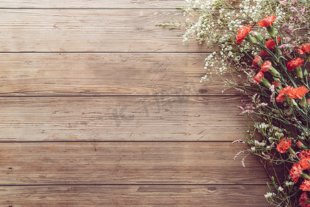 木板桌背景上平铺的花园春白红小花，有复制空间，复古色彩风格