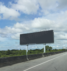 白色宣传海报摄影照片_黑色空白广告牌或广告海报在高速公路或立交桥的一侧在广告概念中的蓝天背景