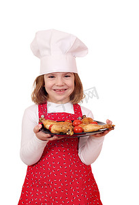 快乐的小女孩用盘子里的鸡腿做饭