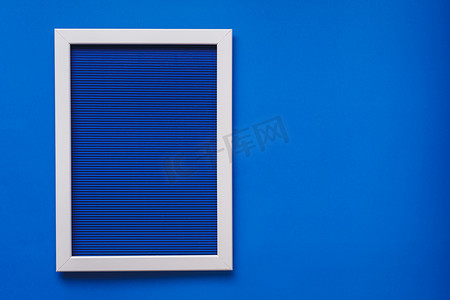 艺术框摄影照片_蓝墙上水平线量皱纸蓝色图案纹理上的空白框