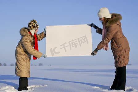 冬天雪地里拿着白色海报的女孩