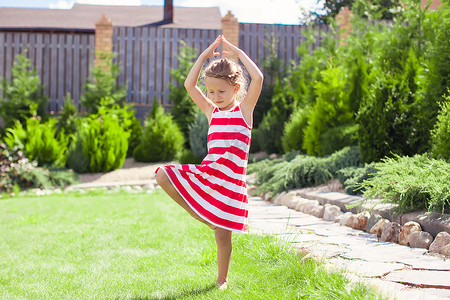 可爱的小女孩单腿站在瑜伽姿势