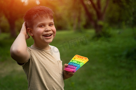 白人小男孩喜欢在院子里用他的 Pop It 弹出泡泡。
