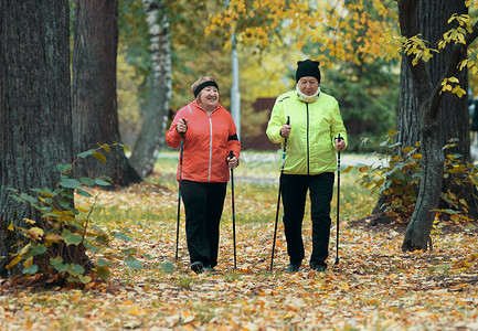 在斯堪的纳维亚散步期间，成熟女性在秋季公园散步。
