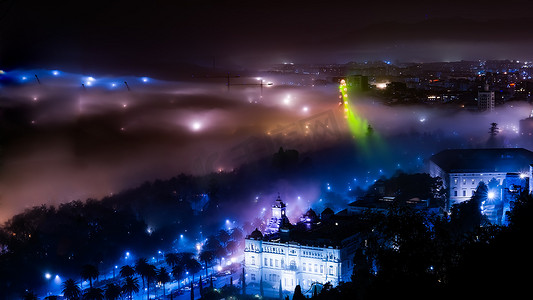 马拉加市雾蒙蒙的夜景，有起重机和摩天轮，Spa