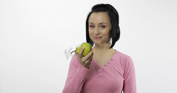 年轻漂亮的女人，带着大的、新鲜的、多汁的绿梨