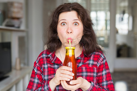 喝果汁的女孩摄影照片_健康的生活方式、维生素饮料和饮食概念 — 快乐女人在家喝果汁的特写