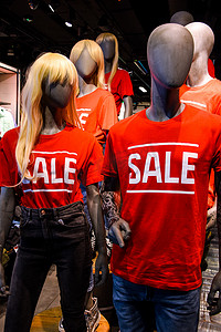 带有标志广告销售的 T 恤服装店橱窗中的人体模特