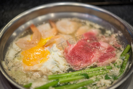 寿喜锅摄影照片_在火锅中烹饪食物以制作寿喜烧或涮锅