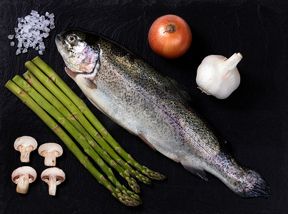 全鱼摄影照片_天然板岩上带蔬菜和香料的生全鱼