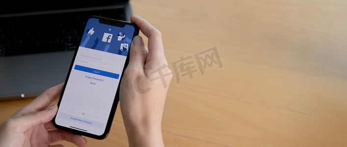 苹果x摄影照片_泰国清迈，2021年8月18日：一名女子手持 iPhone X，屏幕上显示社交互联网服务 Facebook。