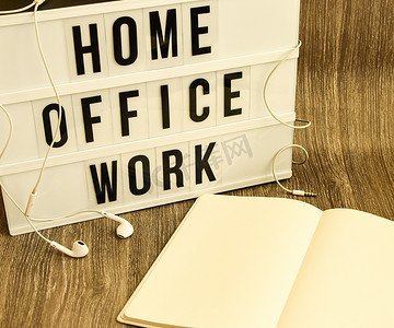 带文本HOME OFFICE WORK的灯箱，带笔记本笔和耳机，复制空间木桌背景，隔离和隔离HOME OFFICE