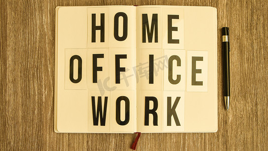 work摄影照片_带文本HOME OFFICE WORK的灯箱，带笔记本笔和耳机，复制空间木桌背景，隔离和隔离HOME OFFICE