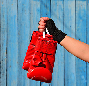 挂在女人手上的绳子上的红色拳击手套