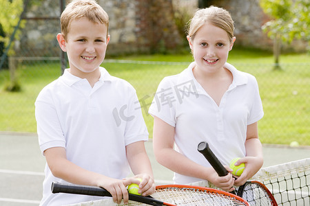 两个拿着球拍的年轻朋友在网球场上微笑