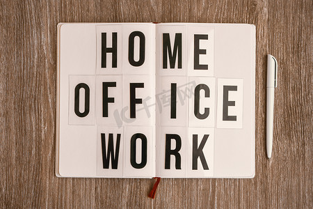 带文本HOME OFFICE WORK的灯箱，带笔记本笔和耳机，复制空间木桌背景，隔离和隔离HOME OFFICE