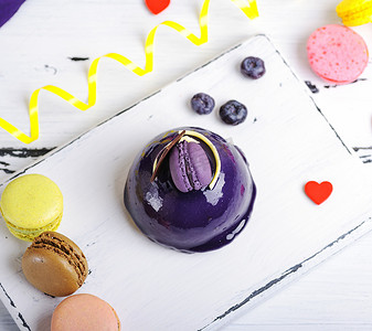 马卡龙背景板摄影照片_带淡紫色软糖和装饰的圆形蛋糕
