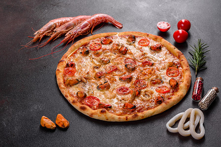 混凝土背景中带海鲜和番茄的美味切片比萨