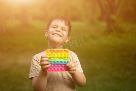 Gigglet Boy 喜欢他的彩色 Pop It 玩具，并在灿烂的夏日阳光下享受日光浴。