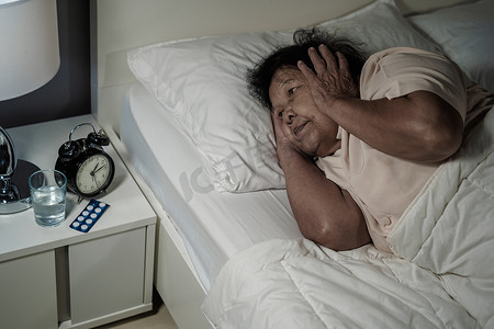 患有失眠症的老妇人正试图在床上睡觉