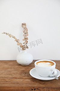 热牛奶摄影照片_木桌上用牛奶制成的卡布奇诺或拿铁艺术咖啡
