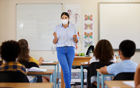 新冠大流行后，年轻女性在课堂上与幼儿学生一起戴着口罩教学。