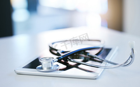 空荡荡的医院、健康和医药保险室桌上的数字平板电脑、听诊器和远程医疗咨询。