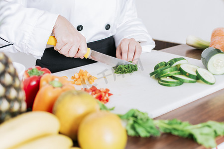 健康搭配摄影照片_厨师手准备和切蔬菜，女厨师切蔬菜的特写，女厨师切蔬菜的手