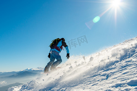 男人滑雪摄影照片_阳光明媚的日子里，滑雪者在山上骑滑雪板。