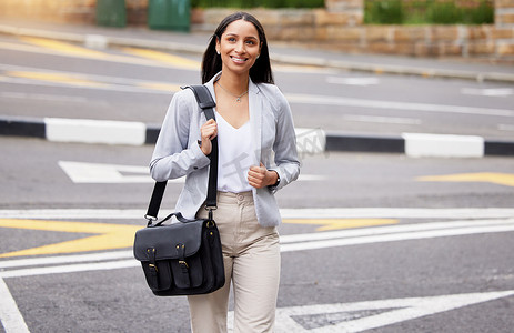 夏天，女商人带着公文包在户外步行去上班时过马路。