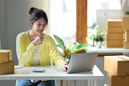 亚洲女企业主在笔记本电脑上确认订单或检查产品采购订单