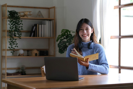 用电摄影照片_亚洲女学生在线学习班学习在线视频通话 zoom 老师，快乐的亚洲女孩用电脑笔记本电脑在线学习英语。