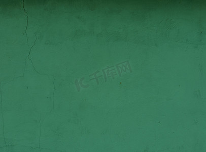 破裂的旧绿色油漆墙面。