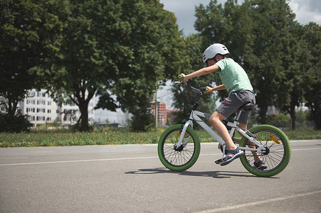 一个学龄男孩在城市里学习极限技巧和极限骑行。