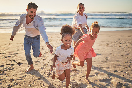 暑假期间，家庭、海滩和孩子们与父母在沙滩上奔跑。
