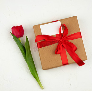 包裹的绿叶摄影照片_一束红色盛开的郁金香，绿叶，包裹着的礼物我