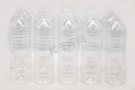 在白色背景上隔离的一排塑料水瓶。