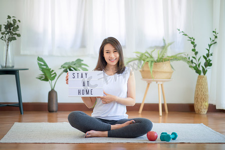 潮流生活摄影照片_美丽的亚洲女性通过在家锻炼健康潮流生活方式来保持健康