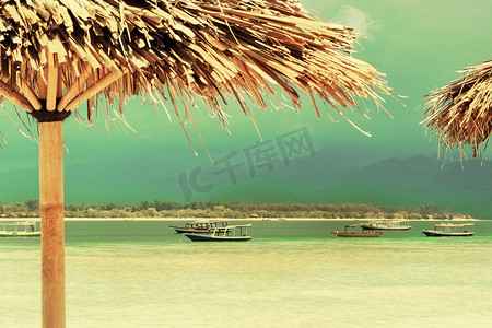 吉利卡片摄影照片_岛上沙滩上的稻草伞。
